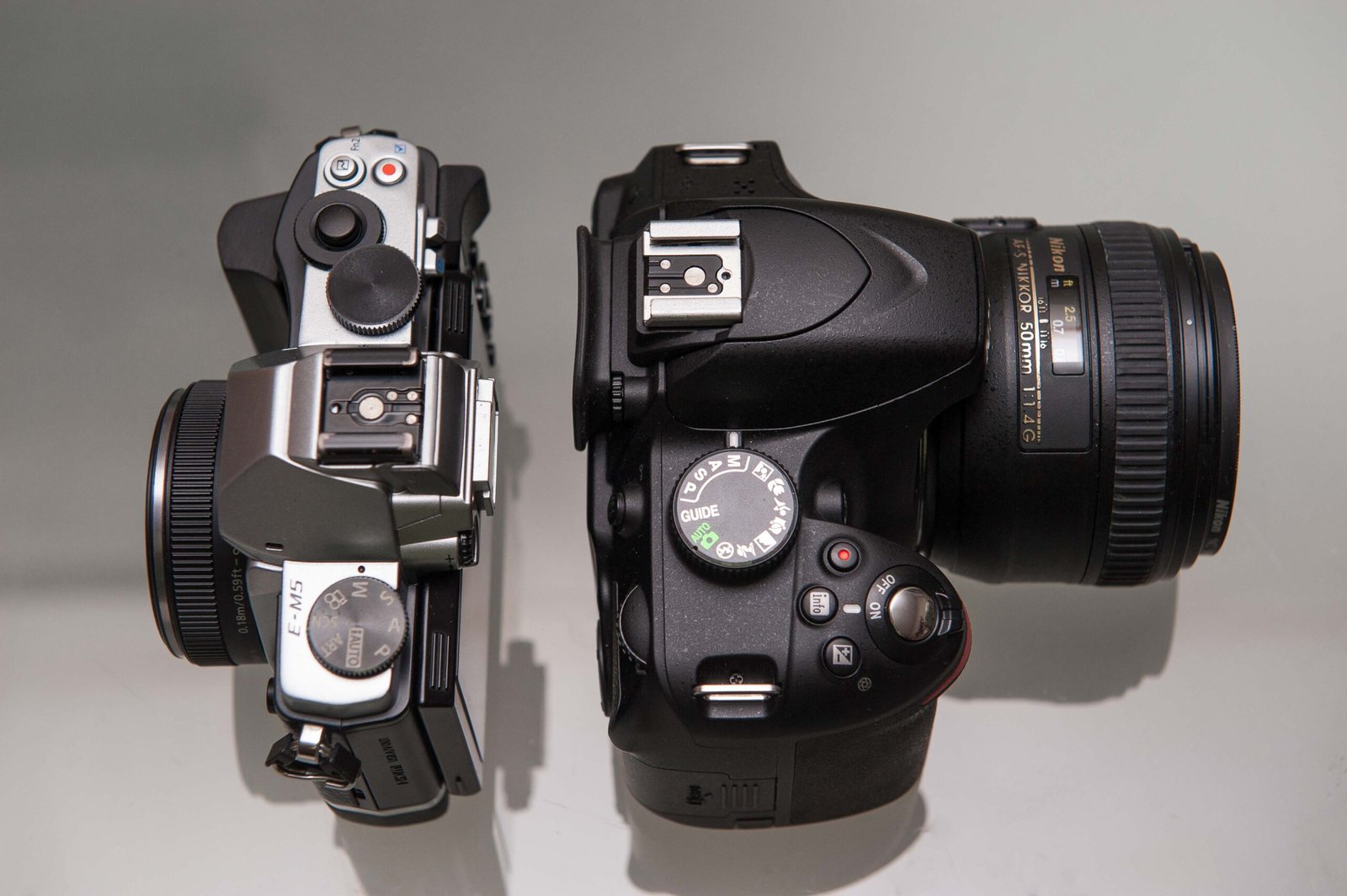 Nikon D3200 DSLR and Olympus OMD EM5 side by side for size comparison